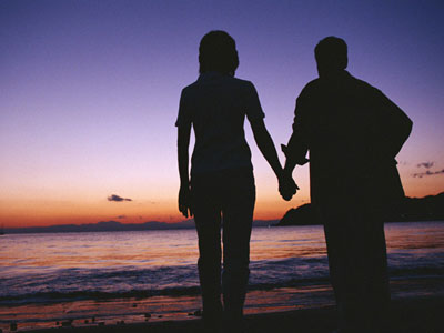夕日の海の中高年カップル